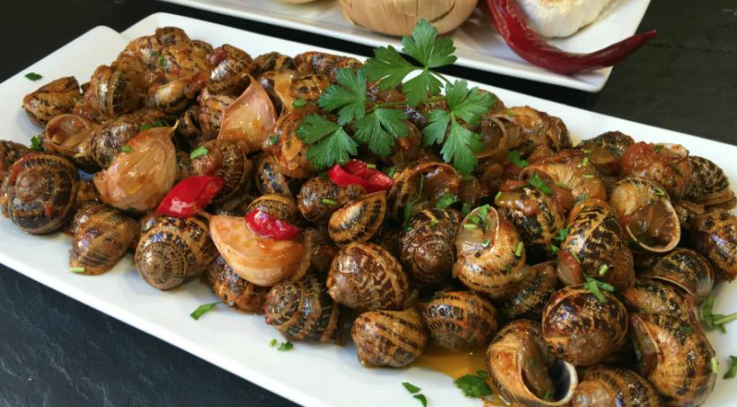 Ensalada de aguacate y salmón con caracoles en salsa picante.